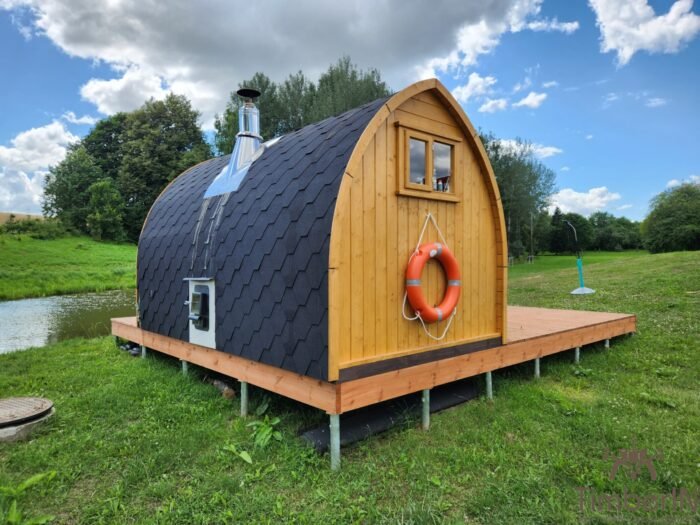 Compact outdoor garden sauna in Ireland with chimney, safety platform and life ring by a lake