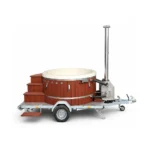 4 Person Hot Tubs 15 Mobile Wood Fired Hot Tub on Trailer – TimberIN Nordic Mobile™ – round wood-fired hot tub with red-brown cladding, cream liner, timber steps, external stainless-steel stove and single-axle trailer on a white background.