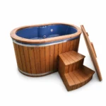 4 Person Hot Tubs 4 TimberIN Nordic Duo oval two-person hot tub with blue fibreglass liner, thermowood cladding, wooden steps and upright insulated cover on a white background.