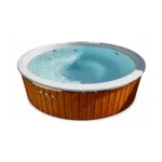 6 Person Hot Tubs UK: Capacity, Water Volume and Heating 4 Electric Wooden Hot Tub for Garden Use – TimberIN Nordic Family™ Electric – round electric hot tub with warm timber cladding, pale moulded liner and bubbling blue water on a white background.