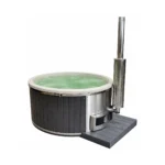 4 Person Hot Tubs 11 TimberIN Nordic™ Pellet Comfort – Wood Pellet Heated Hot Tub – round pellet-heated hot tub with dark vertical cladding, pale liner, external stainless-steel pellet burner, chimney and platform on a white background.
