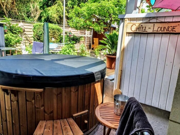 Covered hot tub on a terrace next to garden furniture