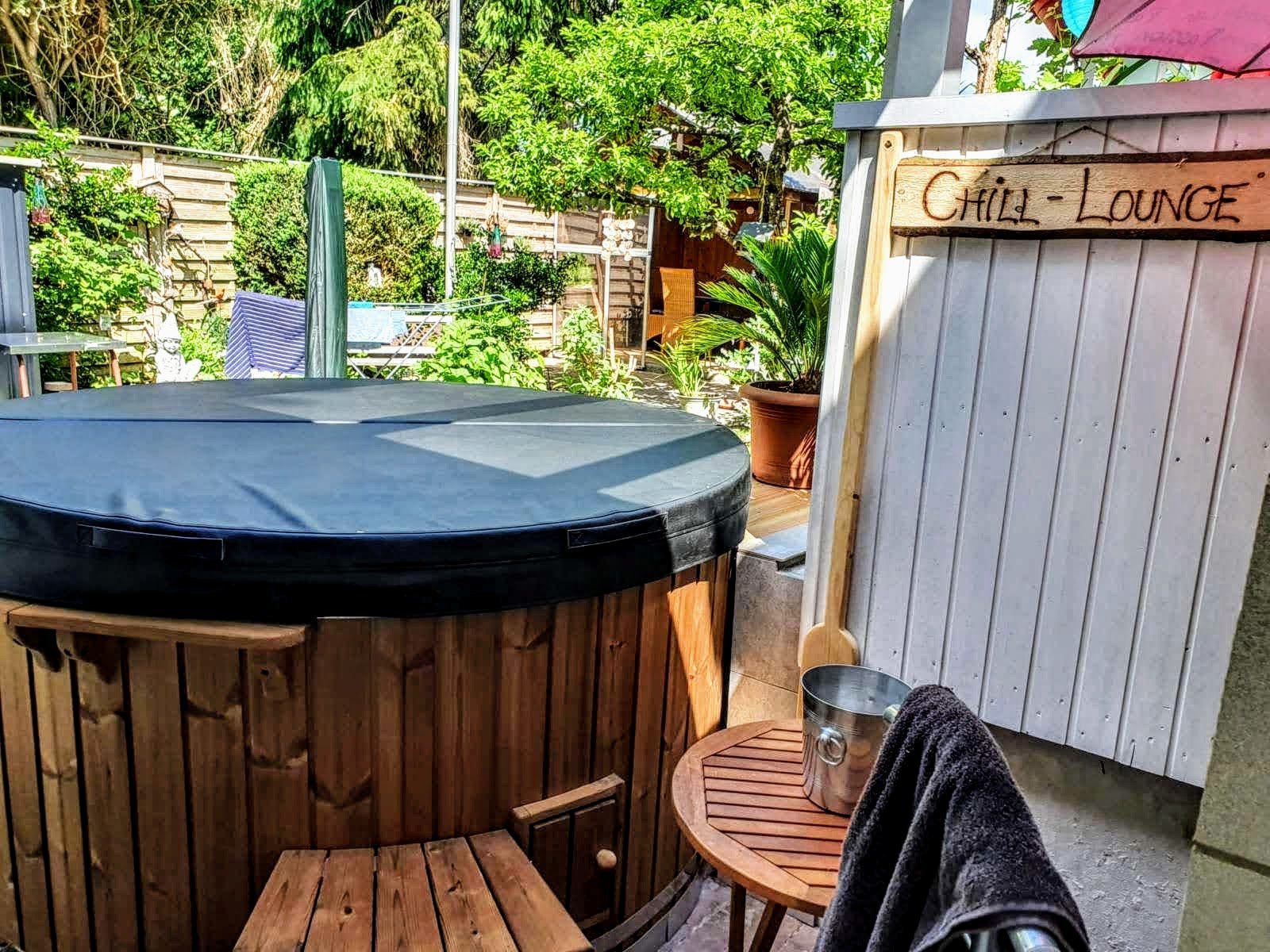 TimberIN UK 10 Covered hot tub on a terrace next to garden furniture