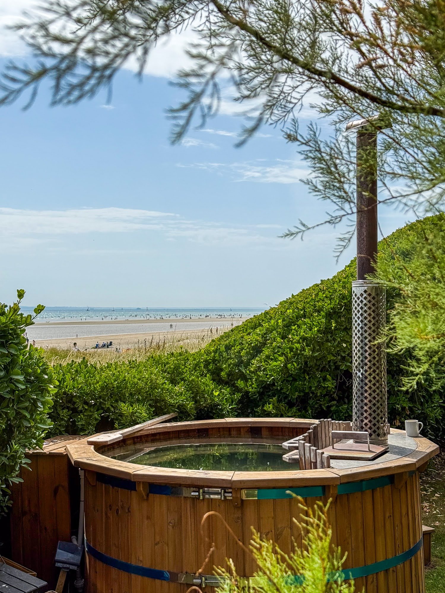 Wood fired hot tubs 1 TimberIN wood-fired hot tub with timber cladding and chimney in an outdoor setting