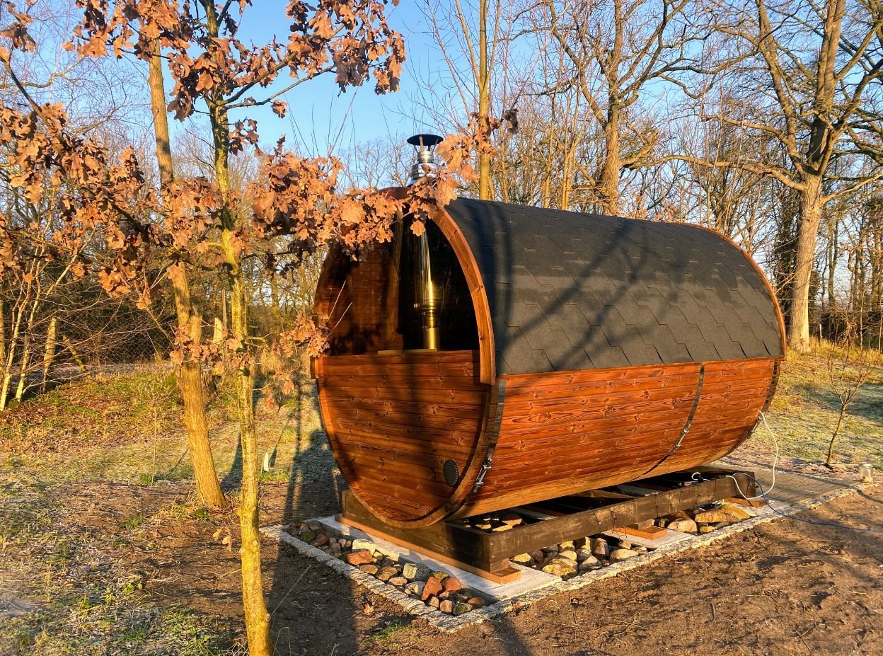 Outdoor saunas 1 TimberIN outdoor barrel sauna installed in a wooded garden at sunset