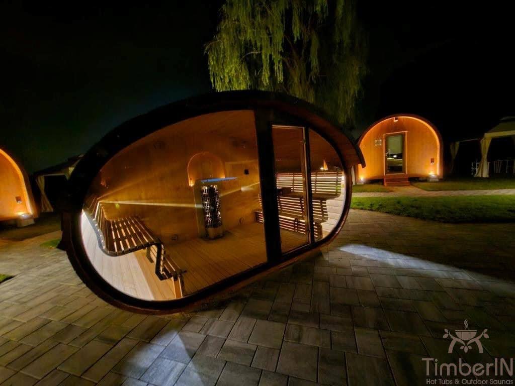 1–2 Person Outdoor Saunas 1 Glass-front TimberIN outdoor sauna at night with timber benches and a central heater