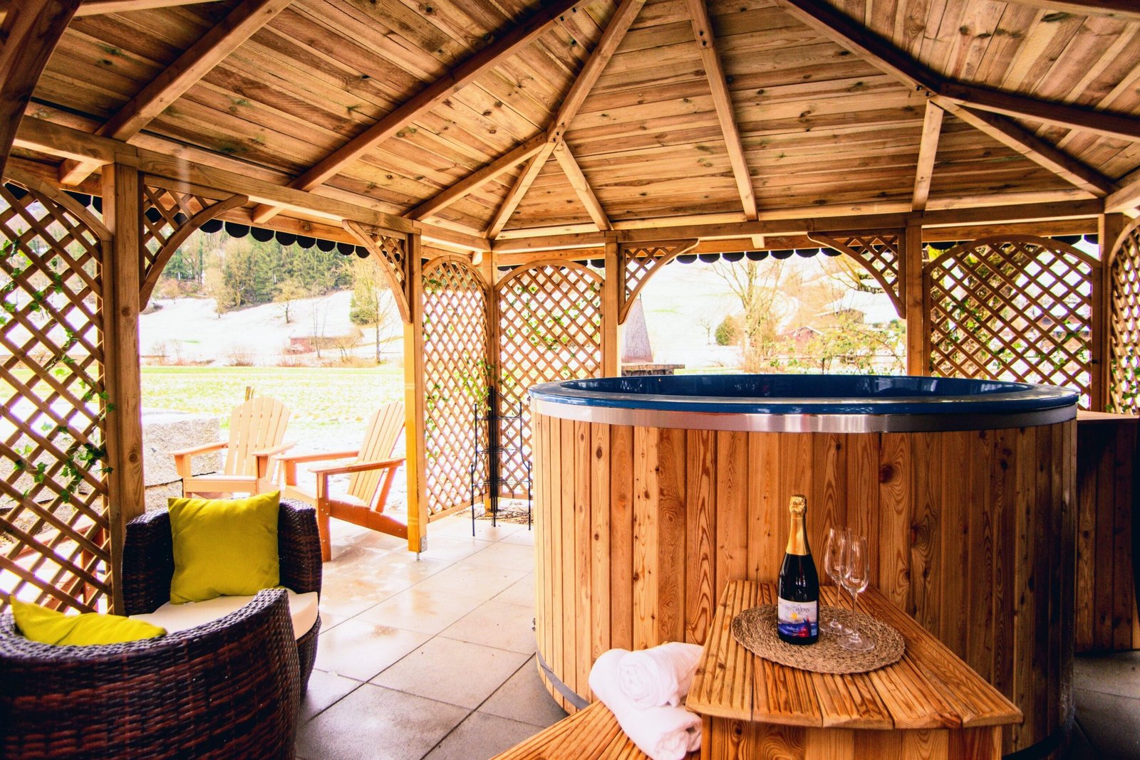 Timber-clad hot tub and garden seating beneath a wooden shelter