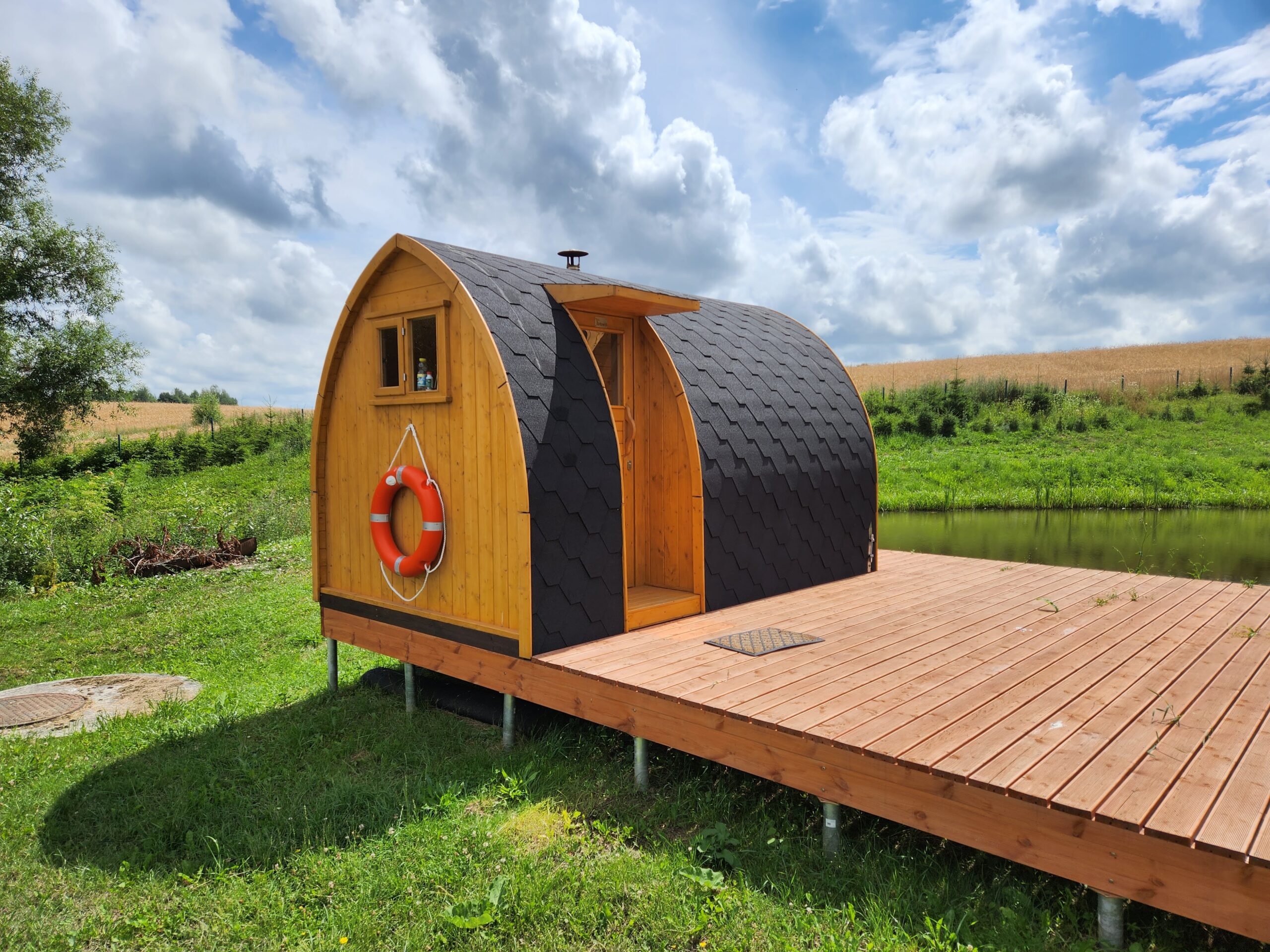 Ireland 1 TimberIN garden sauna pod beside a pond in a rural outdoor setting