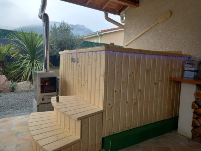 Square wooden hot tub with an external wood-fired stove