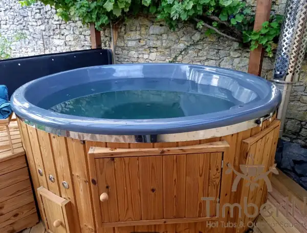 Hot tub with an integrated pellet stove built into the tub