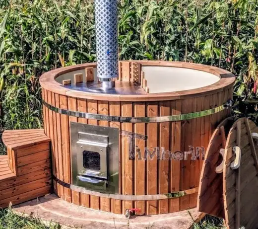 Hot tub with an integrated wood-fired stove loaded from outside