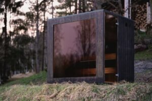 TimberIN Nordic Cube with tinted glass front in a forest