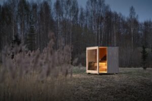 TimberIN Nordic Cube lit sauna in the evening forest